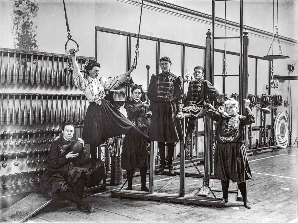 Passionnée de tennis, de vélo ou encore d’automobile, Alice Austen documente l’essor du sport chez les femmes de la grande bourgeoisie à la fin du XIXe siècle. L’existence du Berkeley Ladies’ Athletic Club, un club féminin de gymnastique situé dans Manhattan, est révélatrice du phénomène. En 1893, elle y photographie ses amies : Daisy Elliott (tenant les anneaux), qui dirige le lieu, et avec qui elle a une courte liaison, ou Violet Ward (à l’extrême gauche, tenant un ballon), autre compagne amoureuse de Daisy Elliott.Crédit photo : Collection of Historic Richmond Town