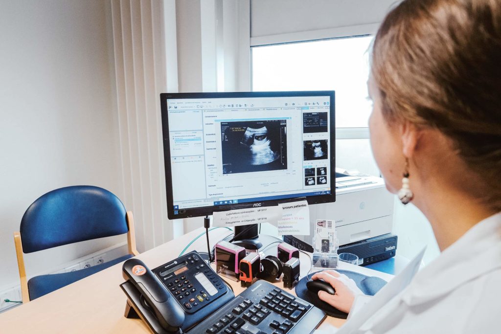 Dans le bureau de consultation, une médecin pratique une échographie.