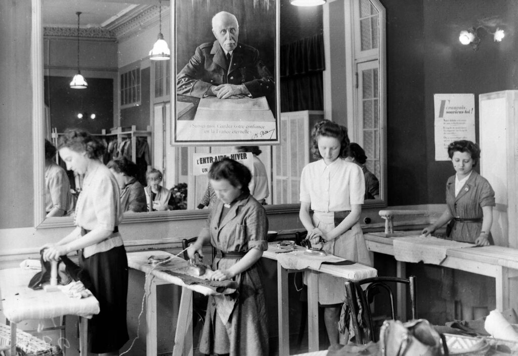 À Vichy, en 1942, sous une photographie du&nbsp;maréchal Pétain, des femmes prennent part à une séance de&nbsp;repassage organisé par le Secours national. KEYSTONE-FRANCE/GAMMA-RAPHO