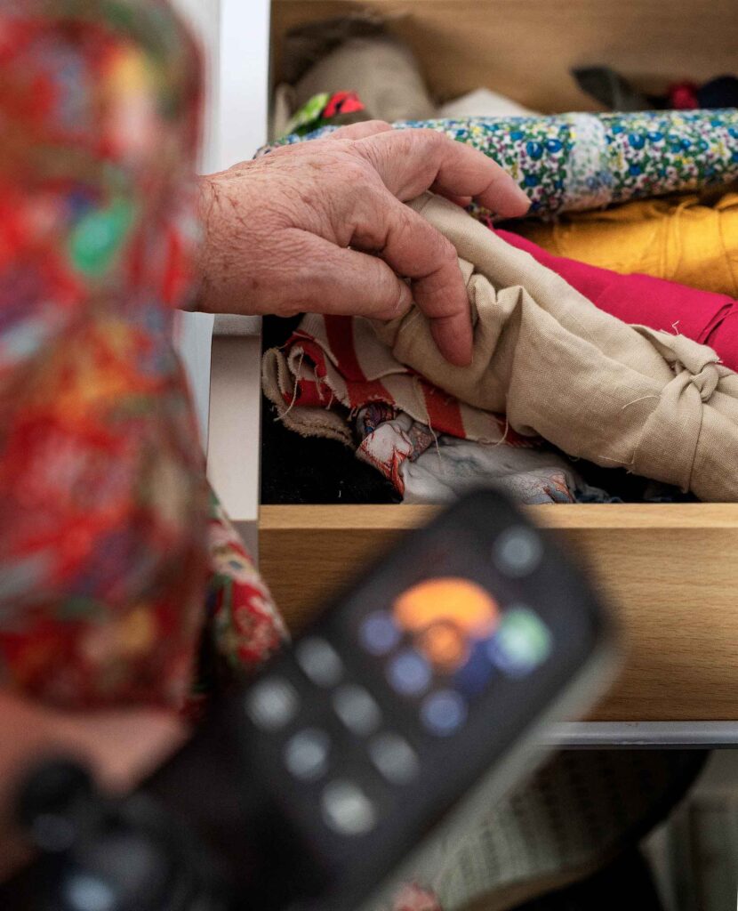 Marie-Claire Pineau Bénudeau en train de choisir un tissu parmi les chutes.