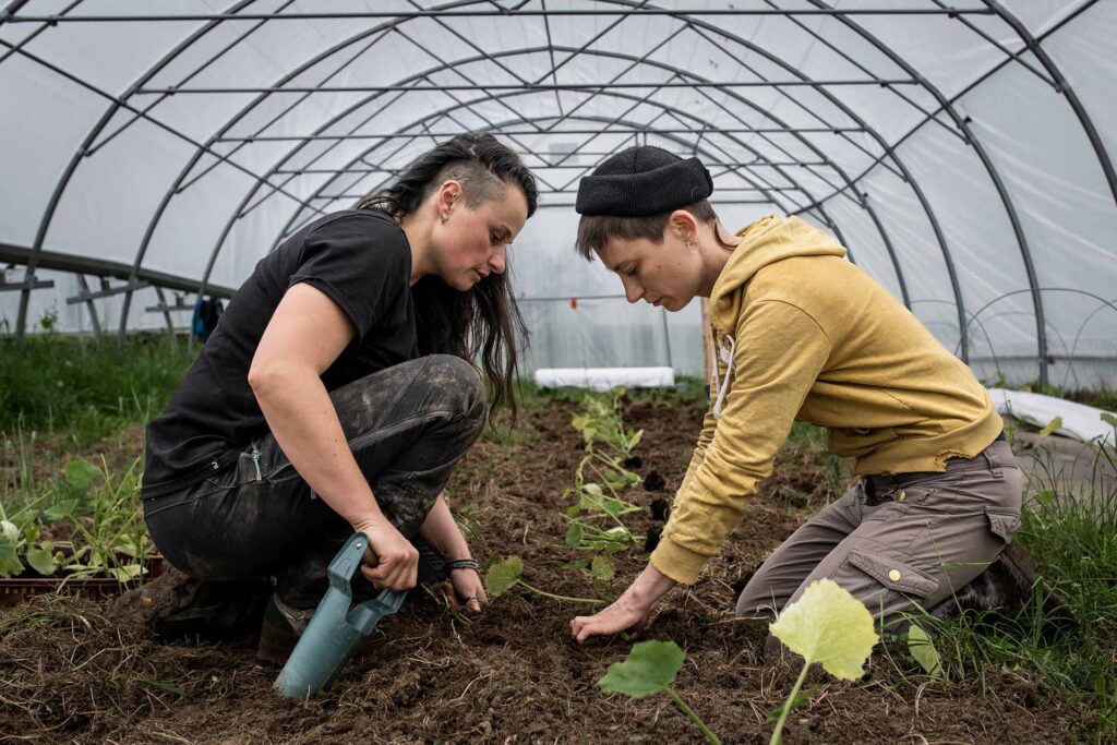 C’est autour de Boubou (à gauche), ici avec sa compagne, Popi, que s’est créée la ferme de la Petite Mouliche, à Cunlhat (Puy-de-Dôme), en 2023. Le collectif de huit personnes souhaitait « produire une alimentation saine et durable ». Boubou, fille d’agriculteur·ices, qui avait éprouvé le besoin de partir jusqu’en Californie pour « s’épanouir en tant que lesbienne », entend aujourd’hui démontrer qu’il est possible de « vivre là où sont ses racines, en étant qui on est ».