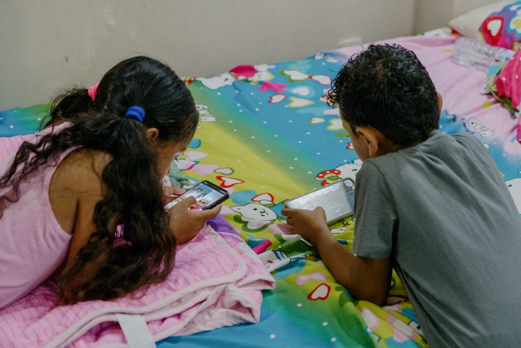 Le 21 juin 2024, Joury Mghames et son frère Jamal jouent sur un téléphone dans l’appartement du Caire où leur famille s’est réfugiée après avoir pu sortir de la bande de Gaza. Alexandre Rito